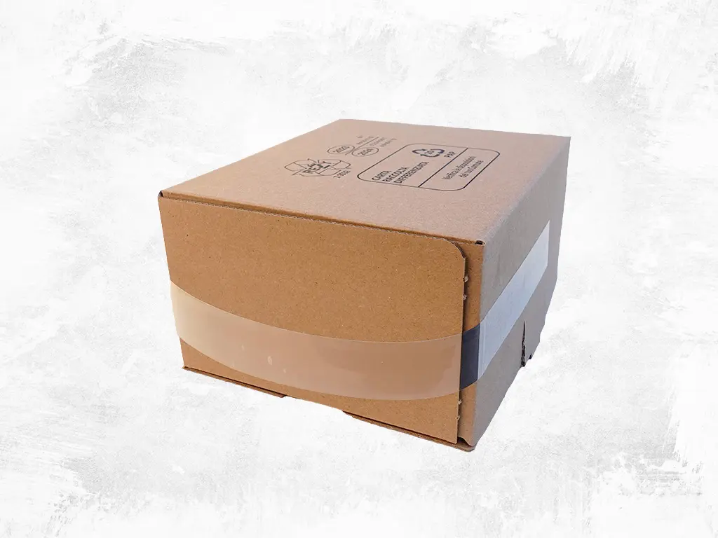 Soluzione manigliatrice XHE per packaging speciale: dettaglio applicazione maniglia adesiva trasparente su scatola di cartone - Installazione Sbe-Varvit. Manigliatrice speciale XHE per scatole: applicazione precisa maniglia adesiva trasparente su packaging Sbe-Varvit.